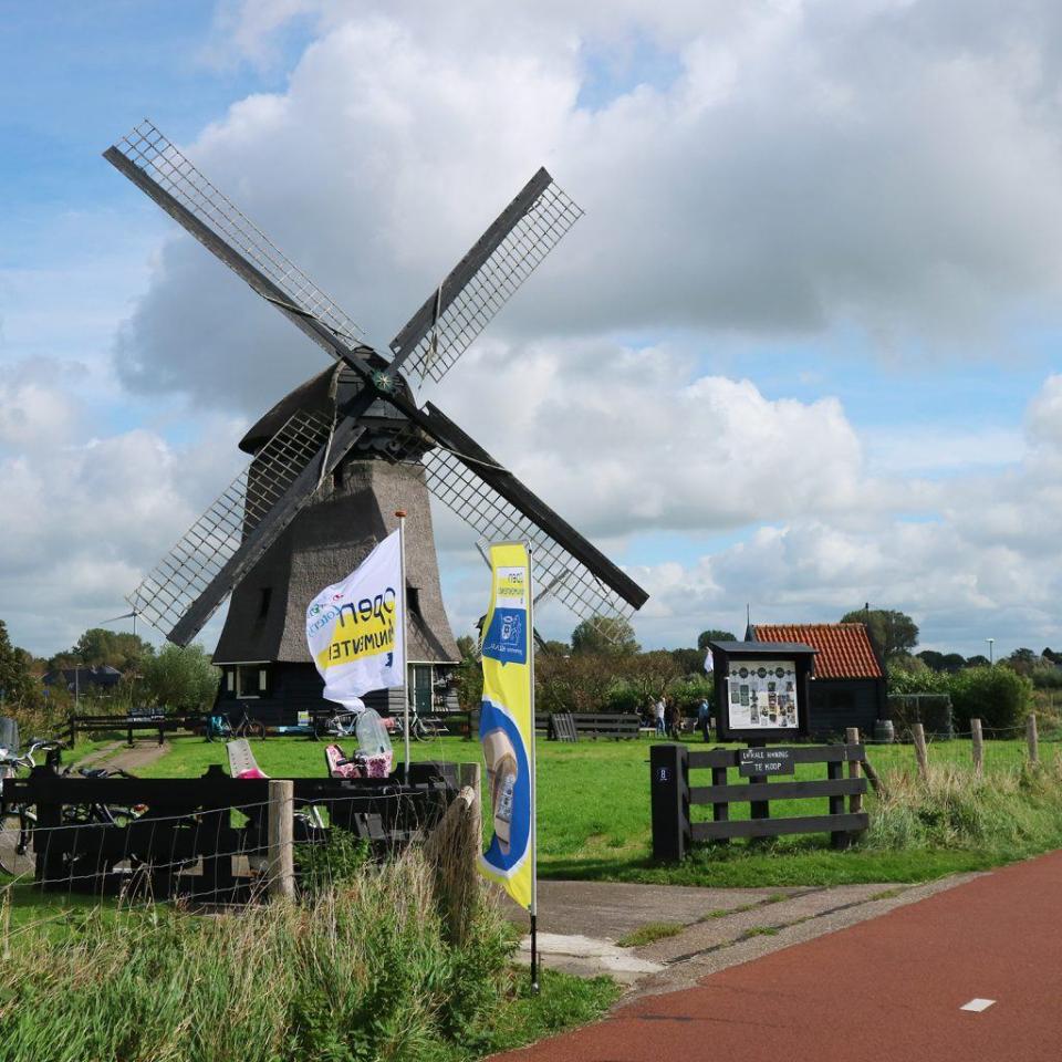 buitenaanzicht Molen D met wapperende vlaggen ervoor